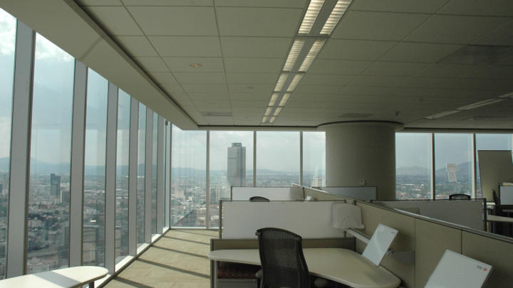Zona de trabajo de la Torre HSBC con la vista exterior iluminada por Philips Lighting