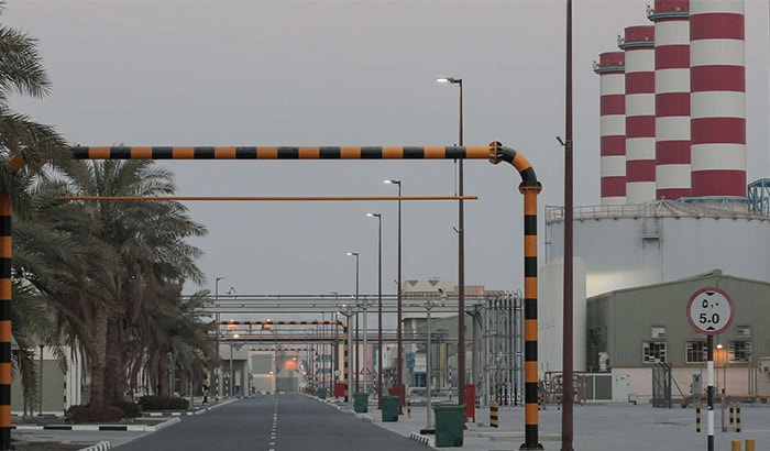 Imagen de una central eléctrica compleja en un entorno tropical un día nublado